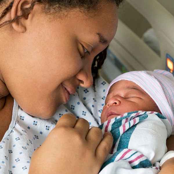 Woman smiling at newborn