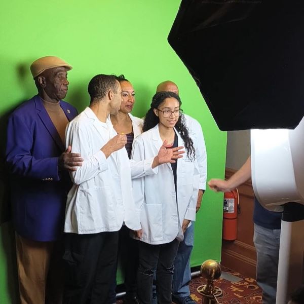 Families and students enjoy the Black Men In White Coats photobooth.