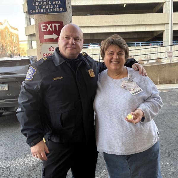 Captain Michael Stokes presents Carmelina Calabrese, Patient Advocate the Put On The Whole Armor of God Coin.