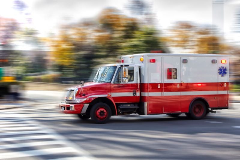 What to Expect When You Call an Ambulance: a red ambulance drives on a city street.