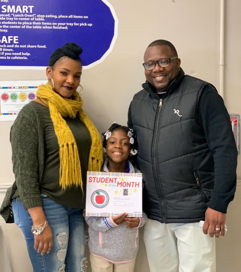 Family with daughter holding award